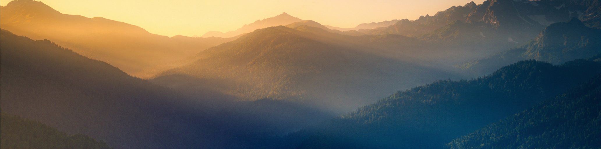 Golden sunrise over a layered mountain range
